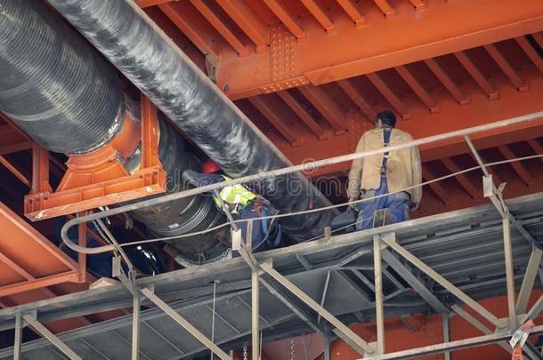 员工焊接法地区<strong>暖气</strong>装置<strong>管道</strong>在下面金属桥