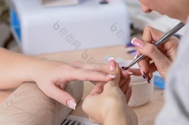特写镜头关于指甲修饰师在使工作,绘画钉子采用钉子沙龙,男人