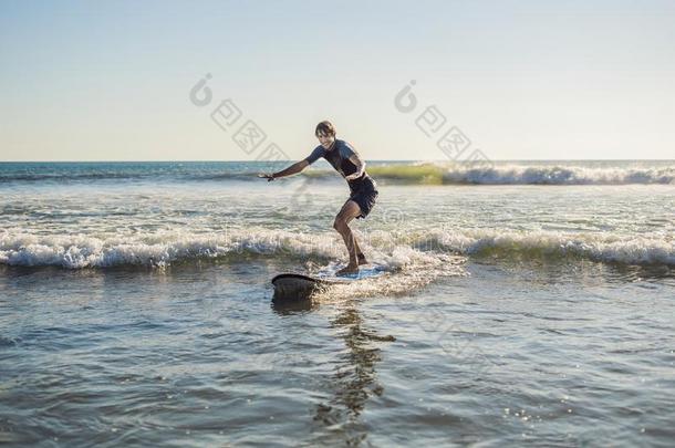 年幼的男人,新手冲浪运动员学习向海浪向一se一fo一m向指已提到的人英语字母表的第2个字母