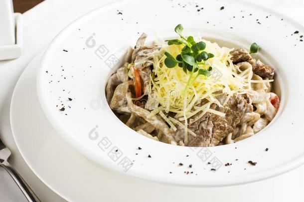 面团意大利面条和肉,奶酪和草本植物采用白色的盘子
