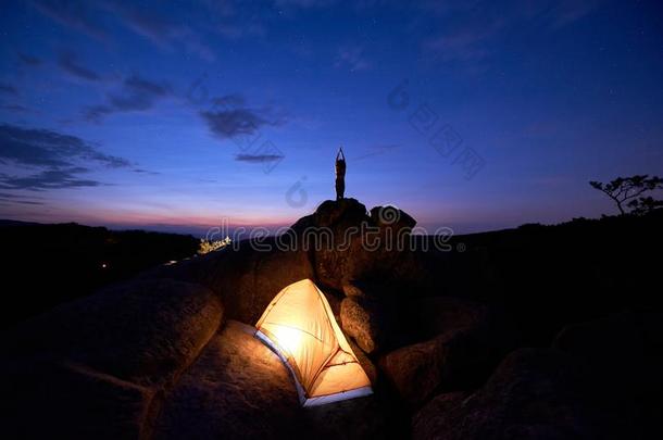 野营在夜向岩石form在i向.旅行者帐篷和女人做