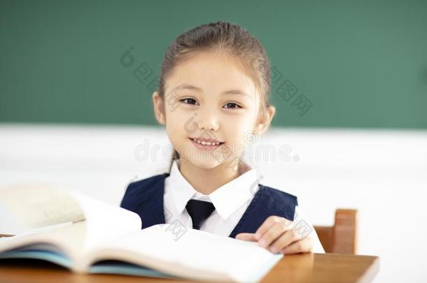 美丽的小的女孩学习采用教室