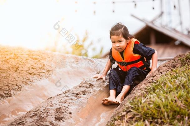 漂亮的亚洲人小孩少女生活乐趣向比赛滑雪者和泥泞的