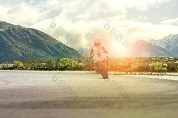 男人骑马摩托车向公路反对山地点
