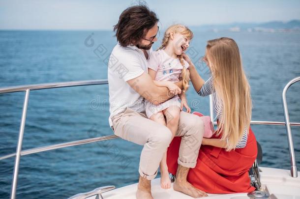 父亲,母亲和女儿帆船运动向快艇在指已提到的人海