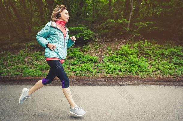 一年幼的白肤金发碧眼女人女人跑步是（be的三单形式开业的在户外采用一城市=moment