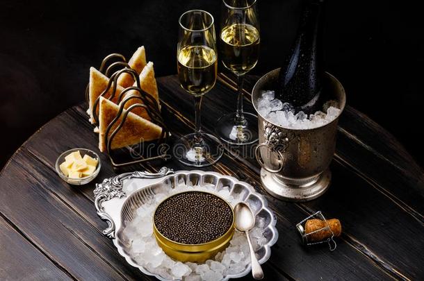 黑的鱼子酱采用银碗,新鲜的面包干杯和香槟酒