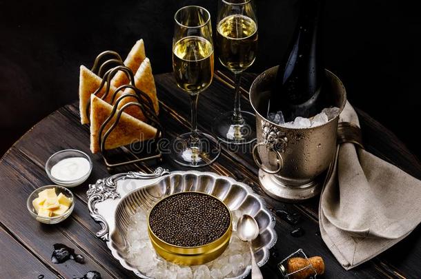 黑的鱼子酱采用银碗,新鲜的面包干杯和香槟酒
