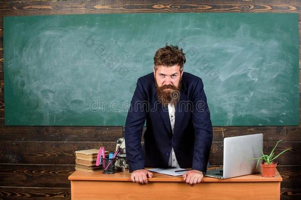 教师精确的严肃的有胡须的男人倾斜向表黑板背