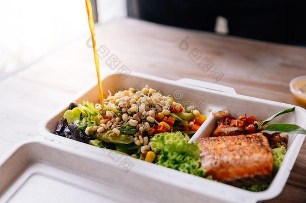干净的食物餐盒:传布沙拉穿衣越过烤的鲑鱼