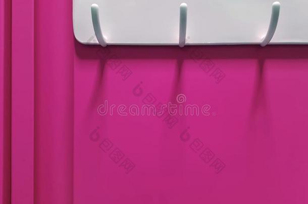 白色的塑料制品衣架钩拳向粉红色的壁橱