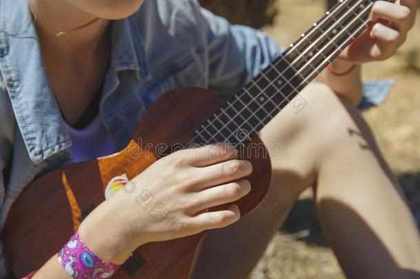 十几岁的青少年女孩演奏夏威夷的四弦琴-夏威夷人吉他