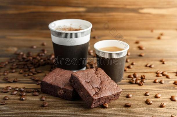 两个核仁巧克力饼蛋糕和纸脸关于卡普契诺咖啡和浓咖啡