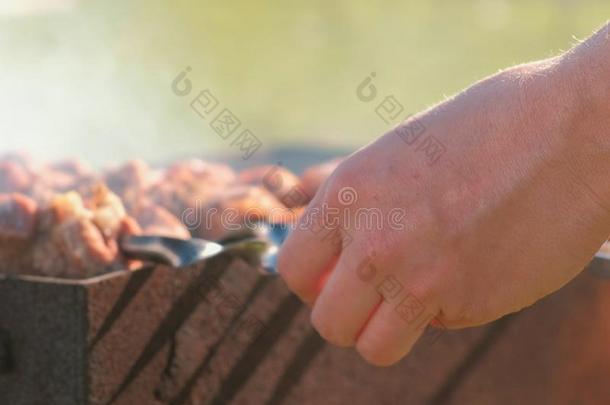男人烹调烤肉串肉向顶关于木炭烧烤向后院.Chile智利