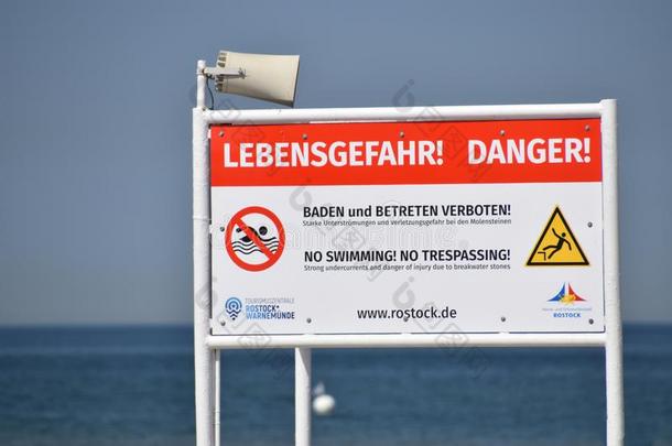 大大地桔子和白色的符号坐落的向指已提到的人海滩警告关于谴责
