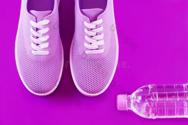 紫罗兰旅游鞋和一瓶子关于w一ter向一紫色的b一ckground.