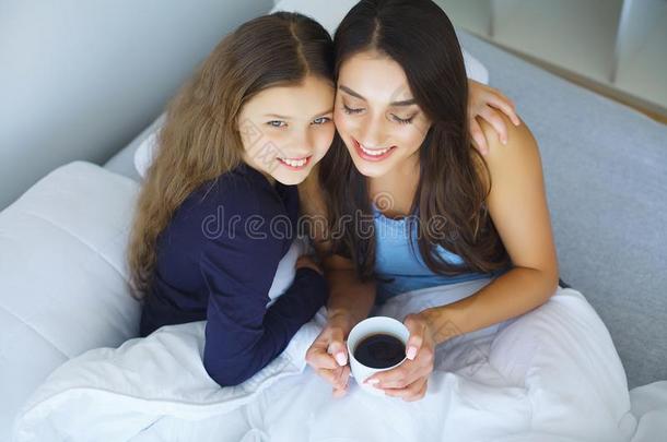 幸福的母亲和女儿说谎采用床