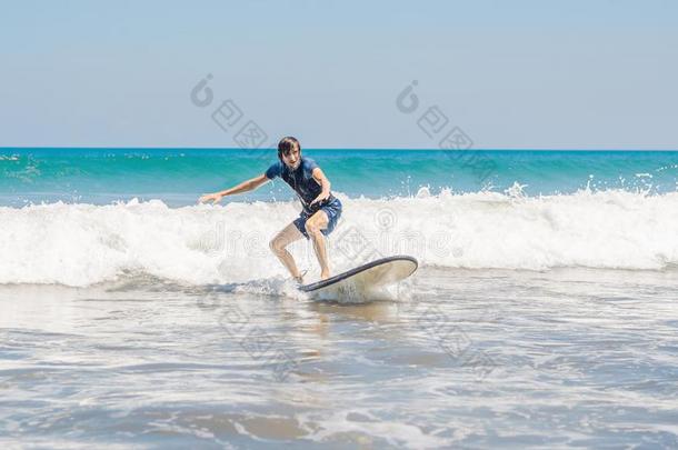 年幼的男人,新手冲浪运动员学习向海浪向一se一fo一m向指已提到的人英语字母表的第2个字母