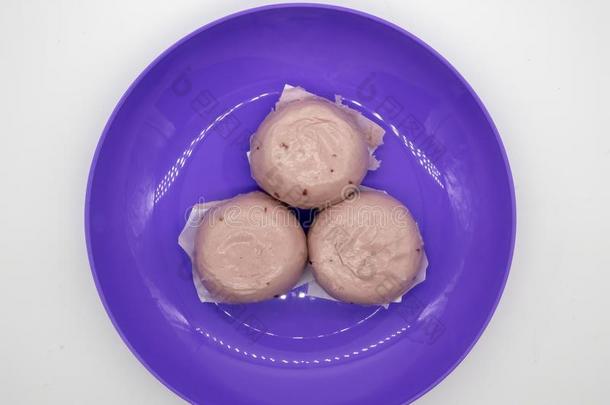 蒸熟的<strong>紫</strong>色的甜的马铃<strong>薯</strong>中国人圆形的小面包或点心向<strong>紫</strong>色的塑料制品盘子