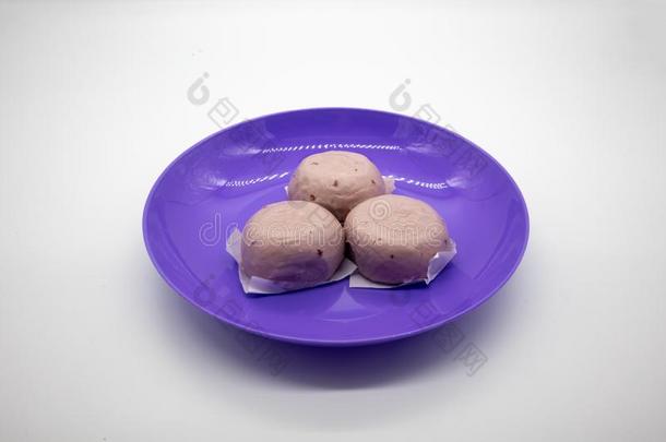 蒸熟的<strong>紫</strong>色的甜的马铃<strong>薯</strong>中国人圆形的小面包或点心向<strong>紫</strong>色的塑料制品盘子