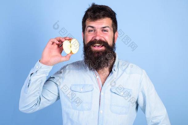 男人有胡须的微笑的保存苹果蓝色背景.卫生保健日常饮食