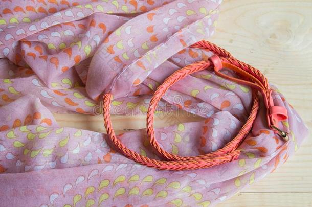 流行的粉红色的附件向木制的背景-围巾,腰带