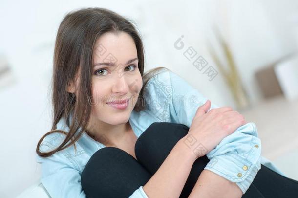 年幼的女孩坐热烈地拥抱膝