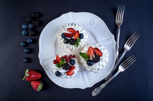 微妙的白色的蛋白糖饼和新鲜的浆果向指已提到的人盘子.德瑟