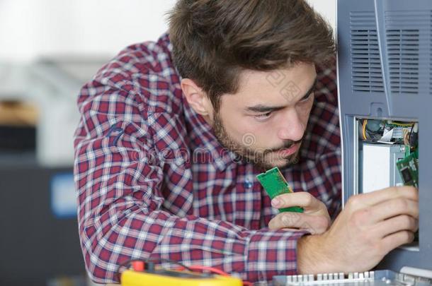 年幼的男人固定personalcomputer个人计算机部在办公室