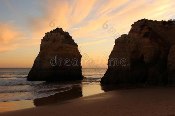 日落在的后面大的悬崖在无人居住的海滩