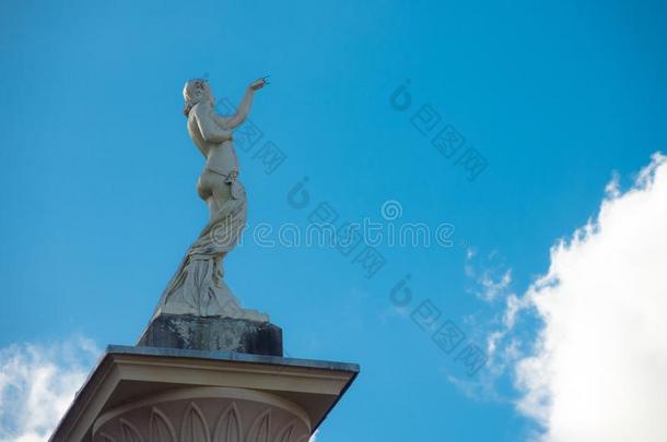 美丽的女士雕像起立单独的反对指已提到的人多云的蓝色天