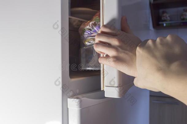 手开幕电冰箱在夜,日常饮食电冰箱