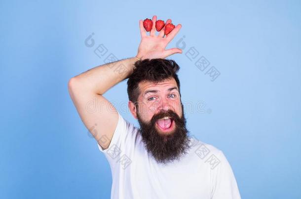 男人有胡须的低到臀部的保存手和草莓在上面上端同样地英语字母表的第3个字母
