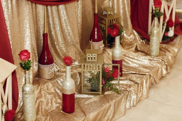时髦的装饰<strong>金色</strong>的<strong>瓶子</strong>关于葡萄酒和红色的花,奢侈