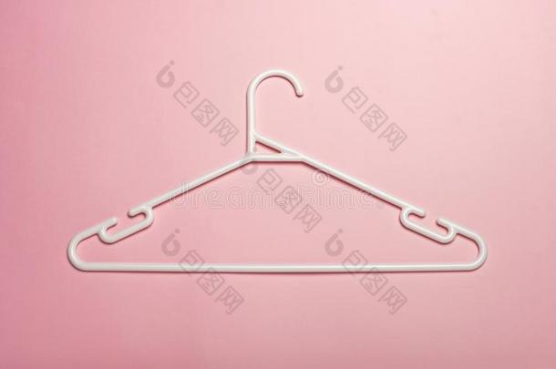 一白色的塑料制品衣服衣架隔离的向粉红色的背景