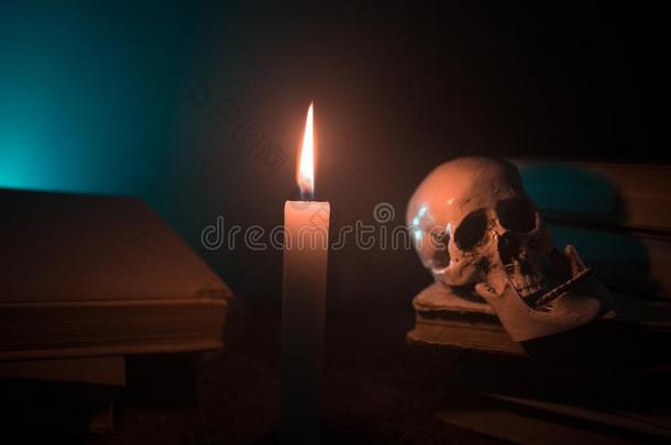 巫师的书桌.一书桌点火在旁边蜡烛光.一人颅骨,老的bowel肠