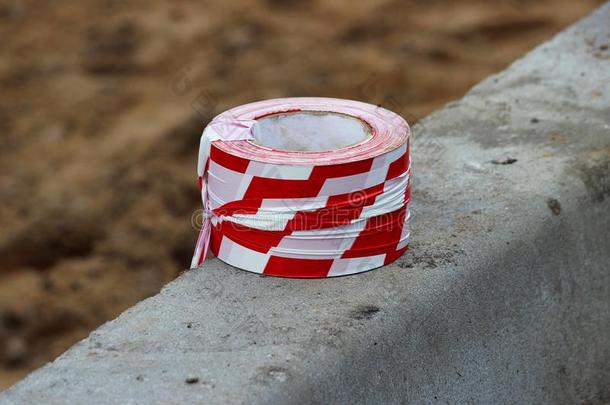 红色的和白色的,有条纹的保护的带子为保护新鲜的沥青