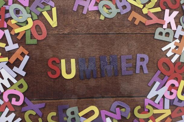 富有色彩的木制的字母表夏拼写向木制的背景