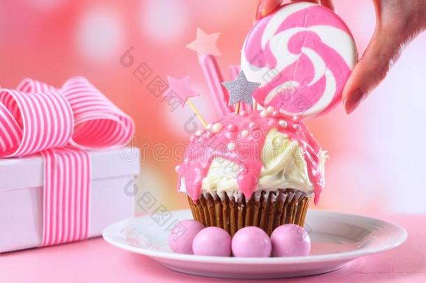 粉红色的<strong>新奇</strong>纸杯蛋糕装饰和糖果和大大地棒棒糖.
