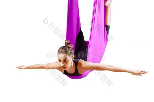 年幼的美丽的瑜珈修行者女人做空气的瑜伽练习采用紫色的