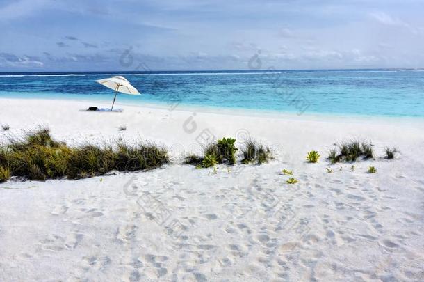 热带的海滩和白色的沙和太阳雨伞采用Maldivi