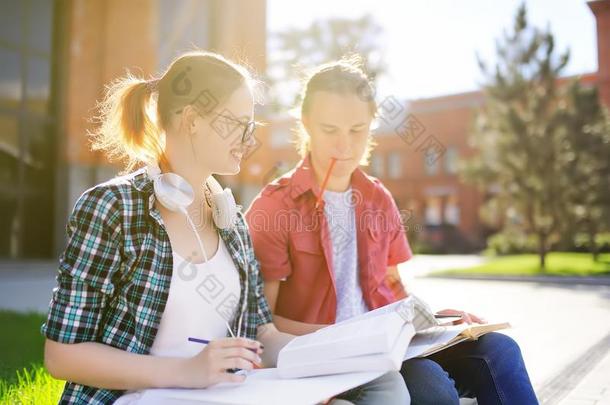 年幼的幸福的学生和书和记下在户外