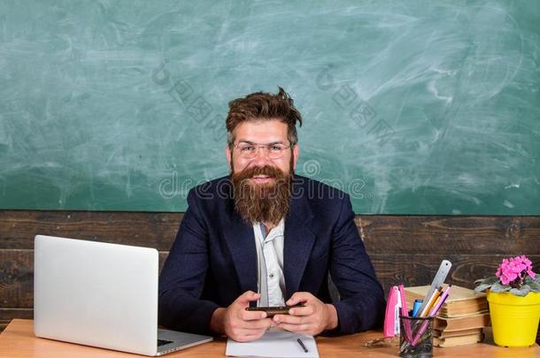 教师有胡须的低到臀部的和眼镜坐采用教室政策