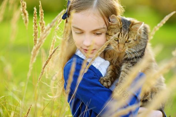 漂亮的小的女孩和她猫向和煦的：照到阳光的秋一天.值得崇拜的children儿童