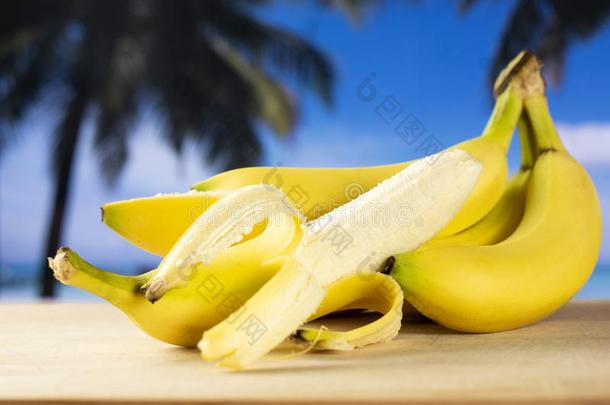 新<strong>鲜的黄色的香蕉</strong>和手掌海滩在<strong>的</strong>后面