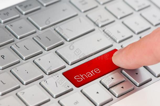 一<strong>手指</strong>压红色的共享<strong>按钮</strong>向便携式电脑键盘