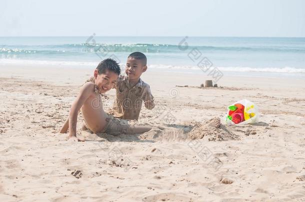 亚洲人漂亮的兄弟和年幼的兄弟所有乐趣向指已提到的人海滩.