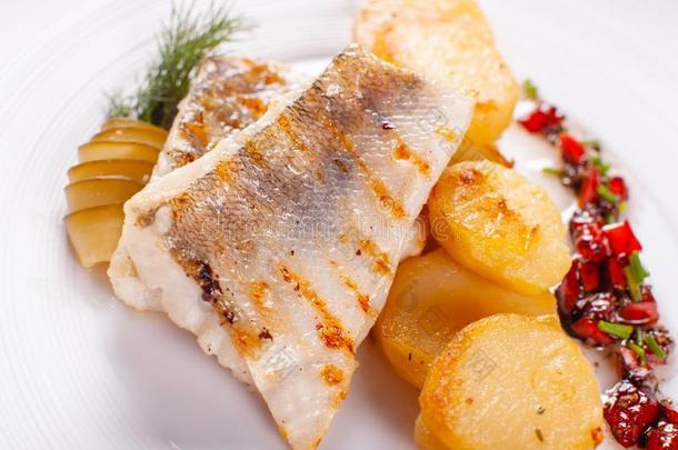 烤鳕鱼,鳕鱼fish和烘烤制作的马铃薯和蔬菜和照片