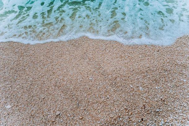 旋转的软的起泡沫波浪关于蓝色绿松石海水向卵石比衣