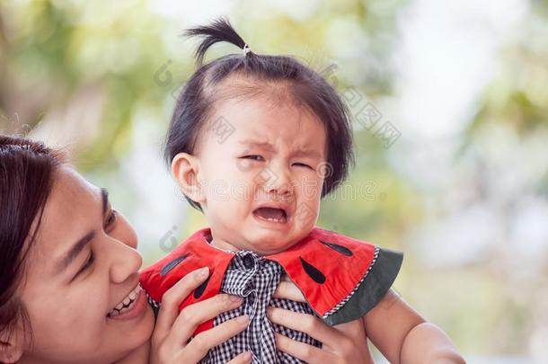 悲哀的亚洲人婴儿女孩极糟糕的和母亲令人欣慰的她